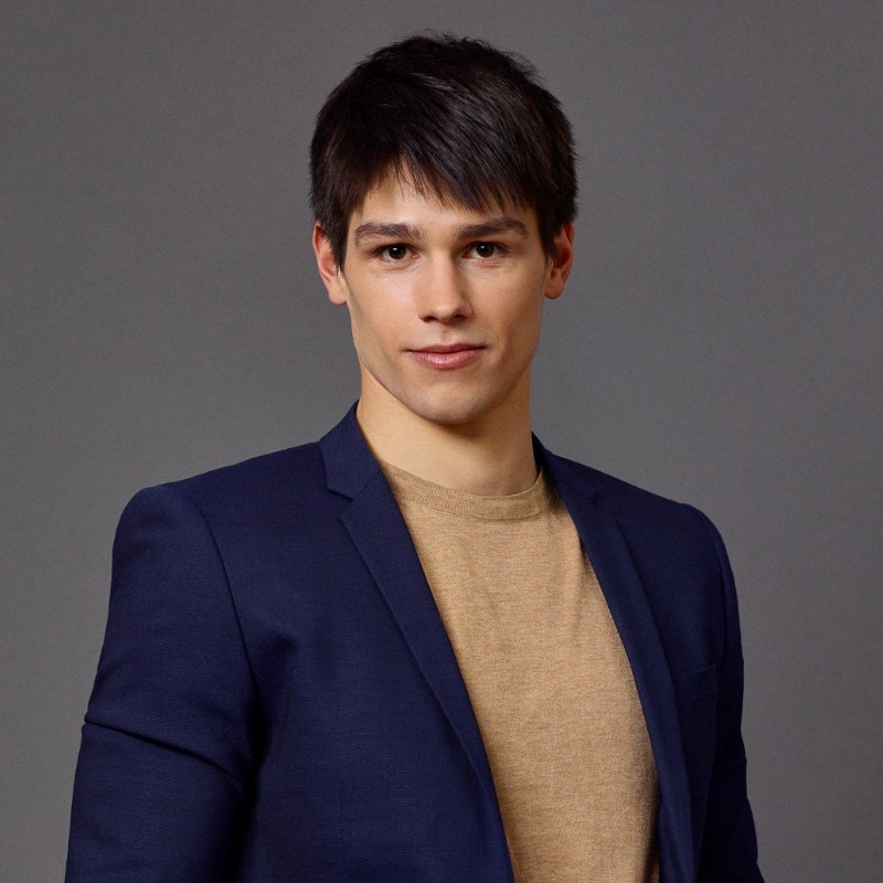 A young man in a suit jacket looking straight at the camera